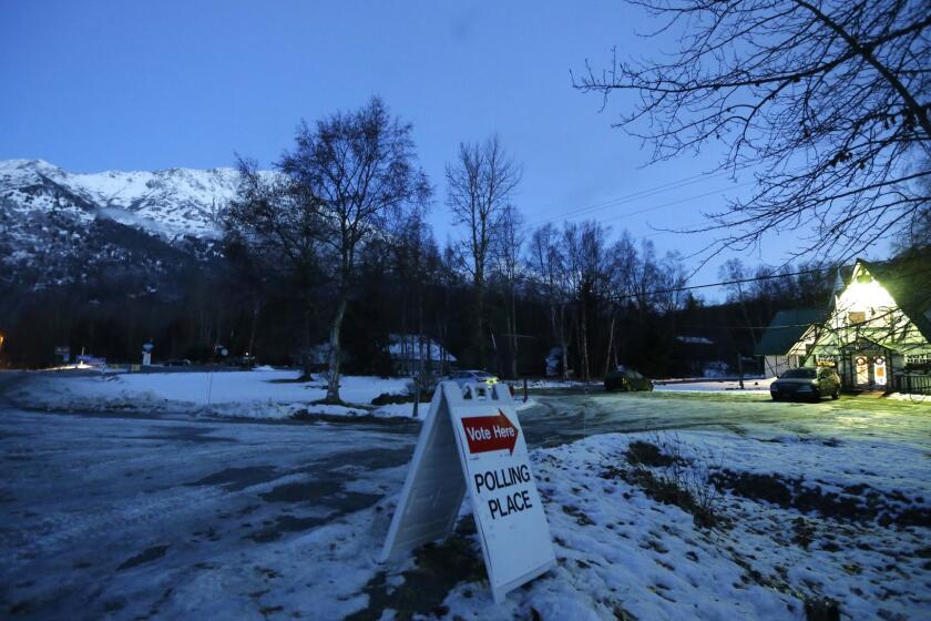 A sign directs voters to the Valley Bible Chalet polling place on Tuesday in Indian, Alaska, south of Anchorage.