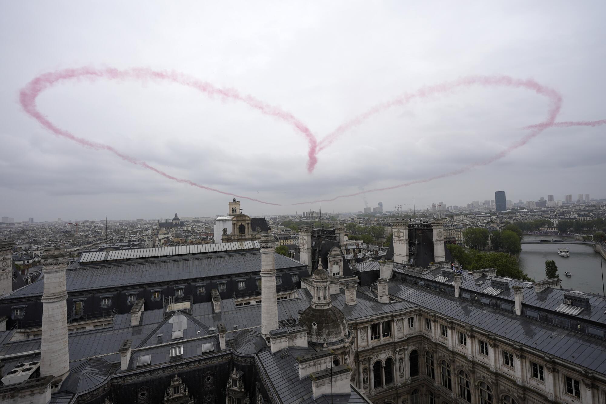 Aircraft make a heart out of smoke over Paris.