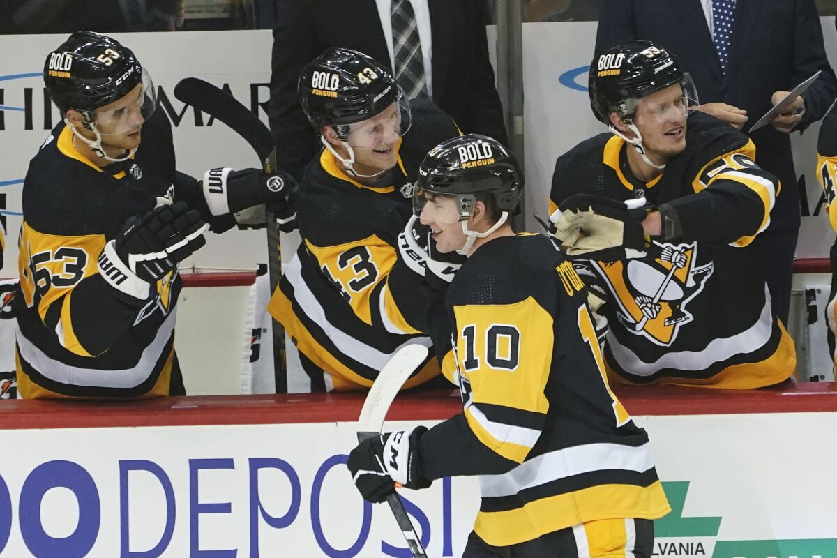 Pittsburgh Penguins' Drew O'Connor (10) is greeted by teammates on the bench after scoring his first NHL goal during the first period of an NHL hockey game against the Chicago Blackhawks, Saturday, Oct. 16, 2021, in Pittsburgh. (AP Photo/Keith Srakocic)