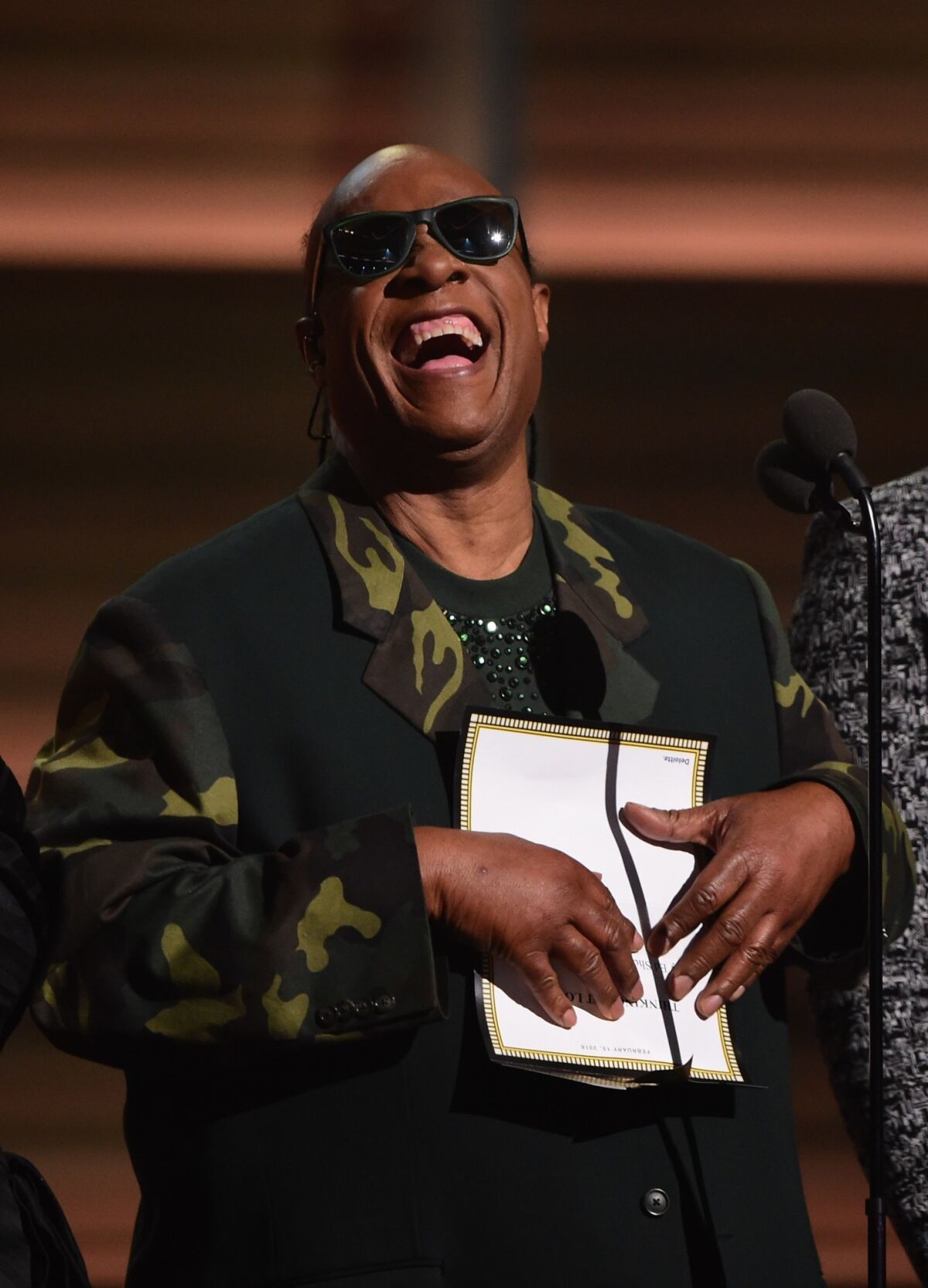 Stevie Wonder cracks himself up with a Braille joke.