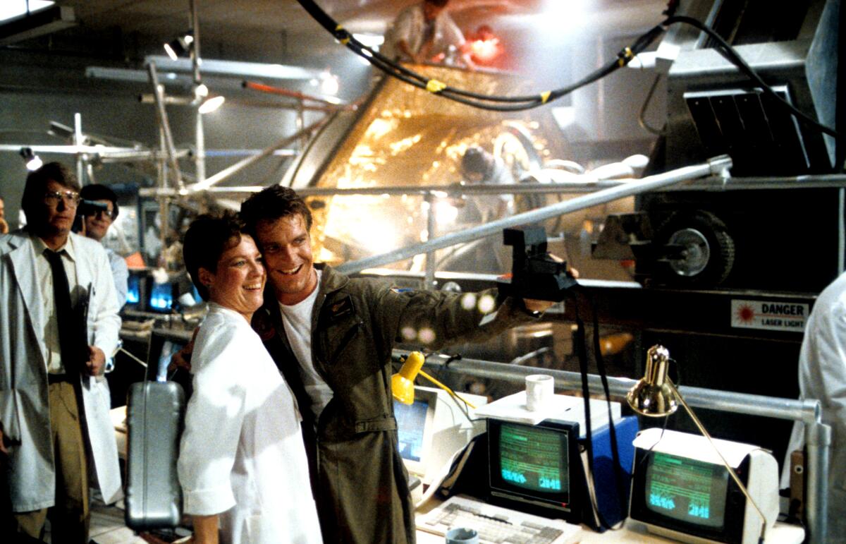 A smiling man poses for a photo in a science lab.