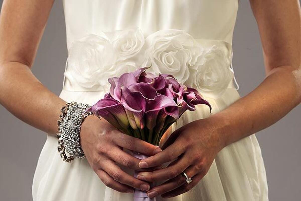 A close-up of the midsection of a wedding dress with a floral cummerbund.