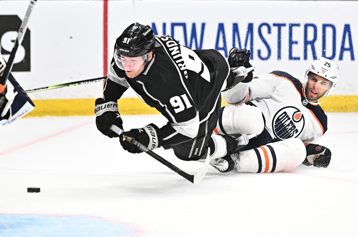 Kings forward Carl Grundstrom falls over Edmonton Oilers defenseman Darnell Nurse as he scores.