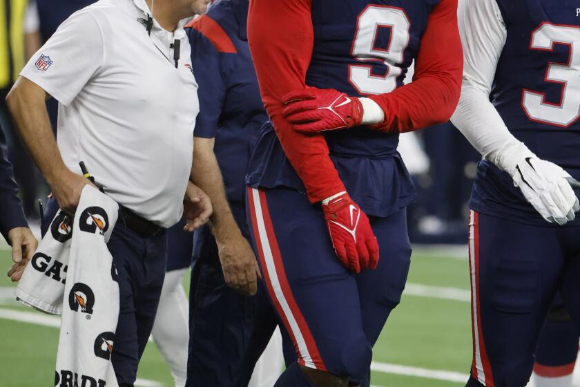 New England Patriots linebacker Matthew Judon (9) walks off the field with teammates and staff after suffering an unknown injury in the second half of an NFL football game against the Dallas Cowboys in Arlington, Texas, Sunday, Oct. 1, 2023. (AP Photo/Michael Ainsworth)