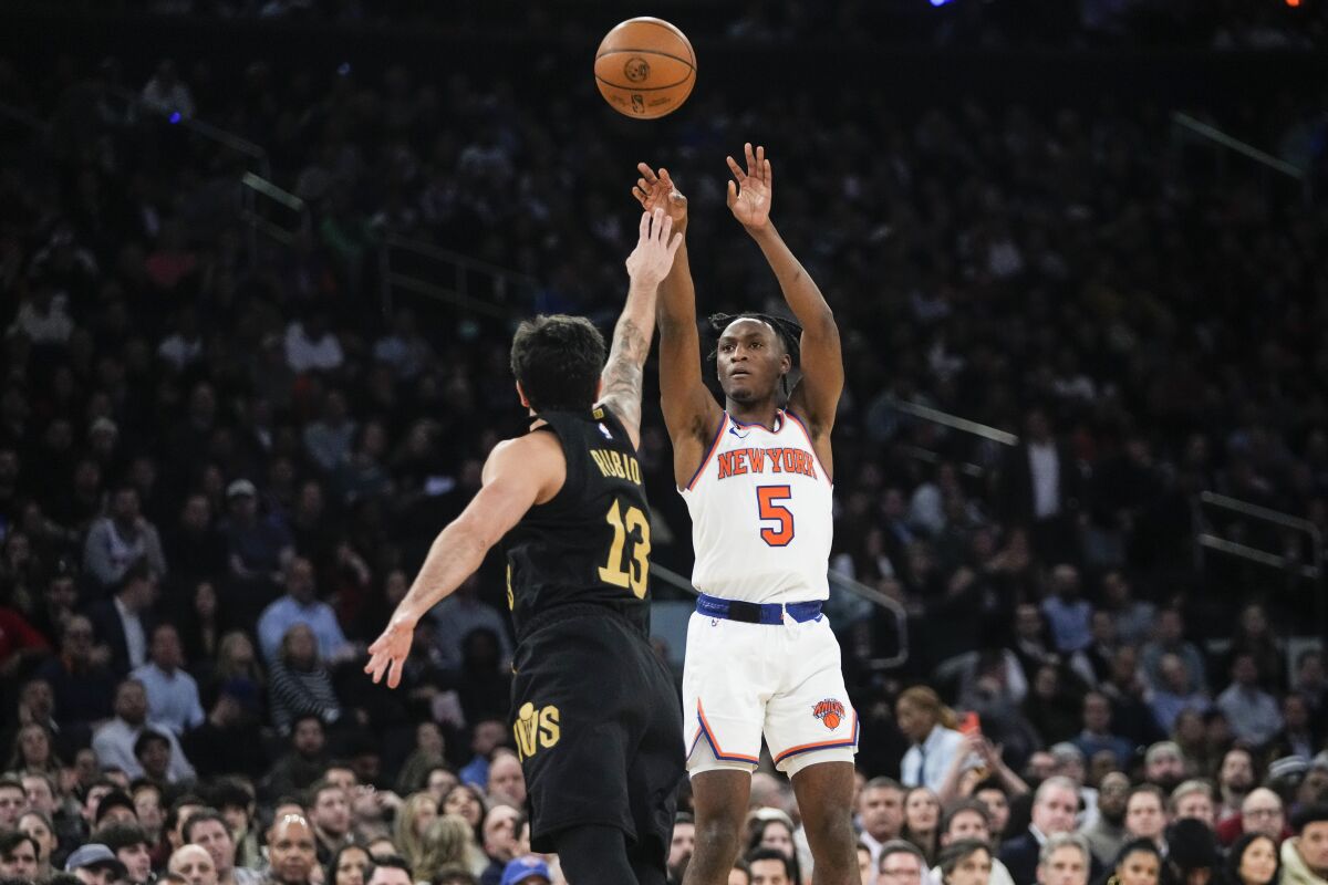 Immanuel Quickley de los Knicks de Nueva York lanza el balón sobre Ricky Rubio de los Cavaliers de Cleveland en el encuentro del martes 24 de enero del 2023. (AP Foto/Frank Franklin II)