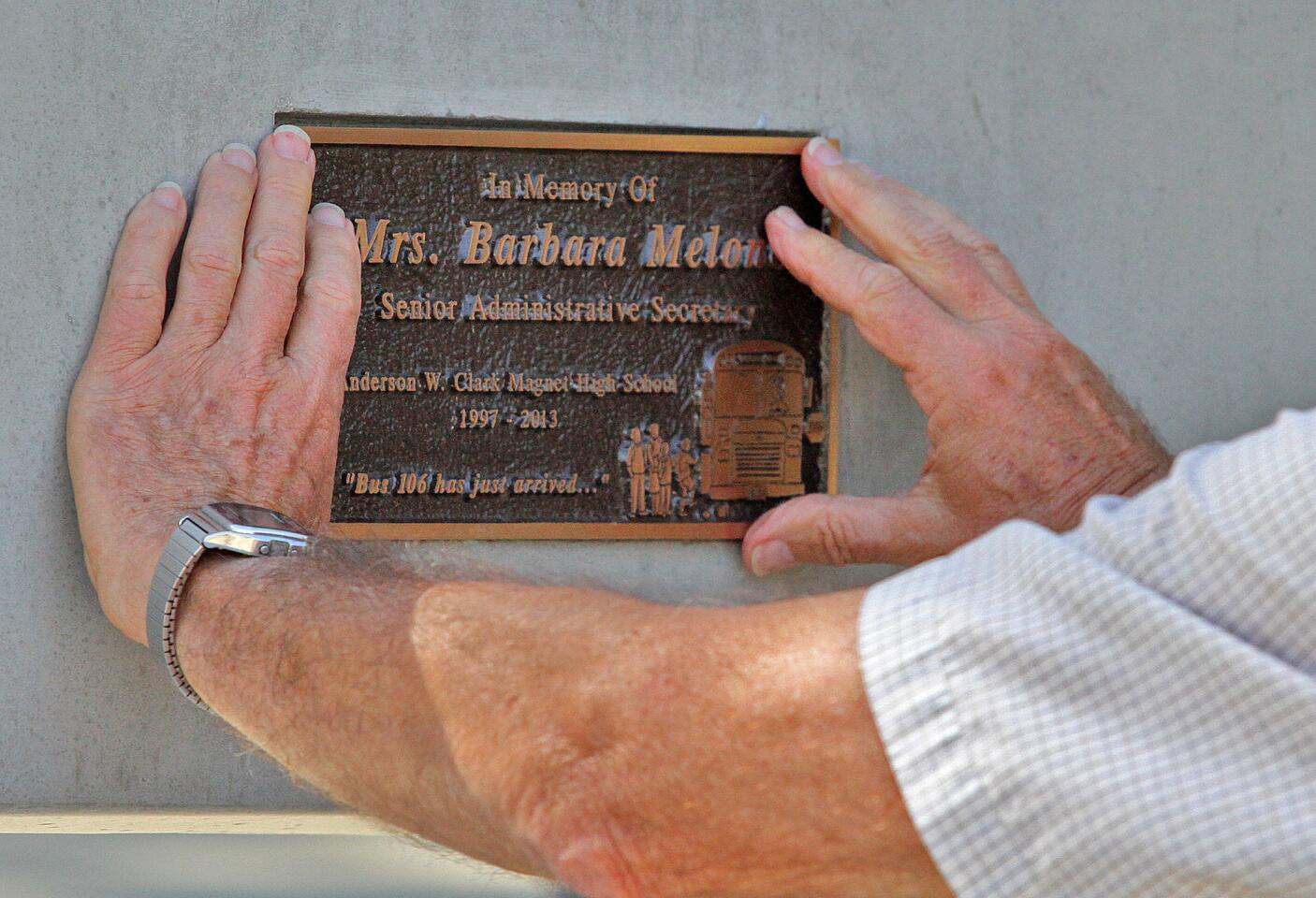 The hands of John Melone, the husband of Barbara Melone, puts a placque on a bench that is being dedicated in her honor at Clark Magnet High School in Glendale on Wednesday, April 30, 2014. Melone a senior administrative secretary at the school, died at the beginning of the school year, and the bench was placed in her honor.