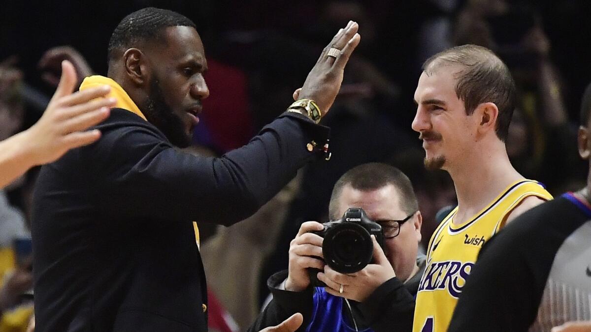 Lakers forward LeBron James, left, congratulates guard Alex Caruso after the Lakers defeated the Clippers 122-117 on Friday at Staples Center.