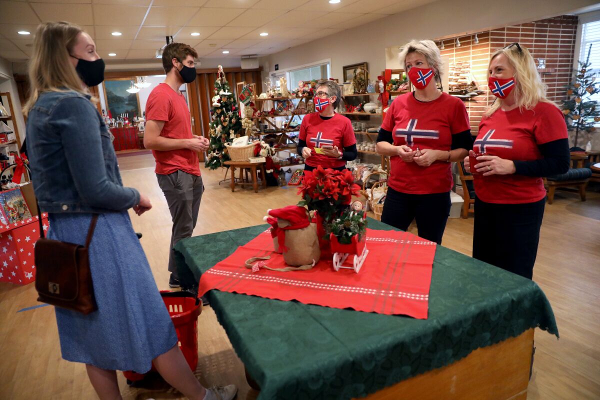 Syhnove Helset and Andreas Helset at Norwegian Seaman's Church gift shop with three people in shirts showing Norway's flag.
