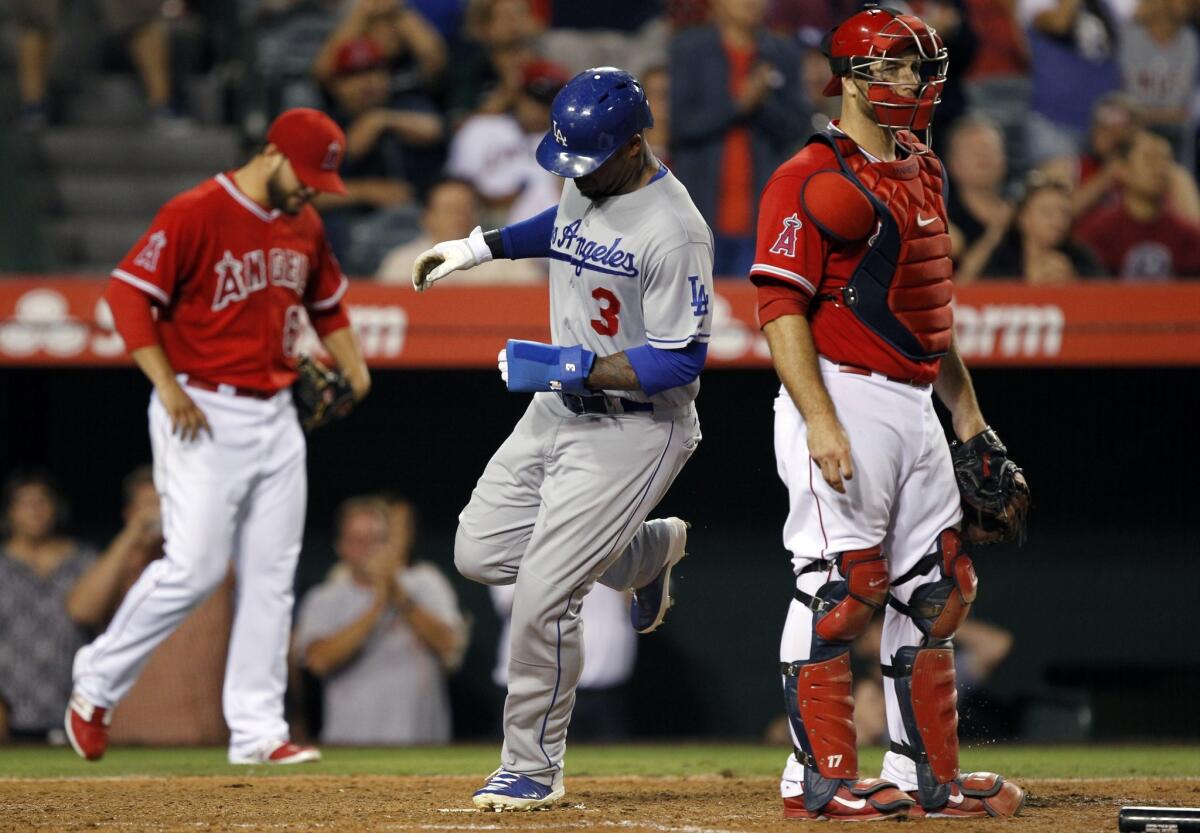 Carl Crawford scores on a single by Miguel Rojas as Angels reliever Cam Bedrosian, left, and catcher Chris Iannetta watch during the ninth inning of the final game of the Freeway Series on Thursday.