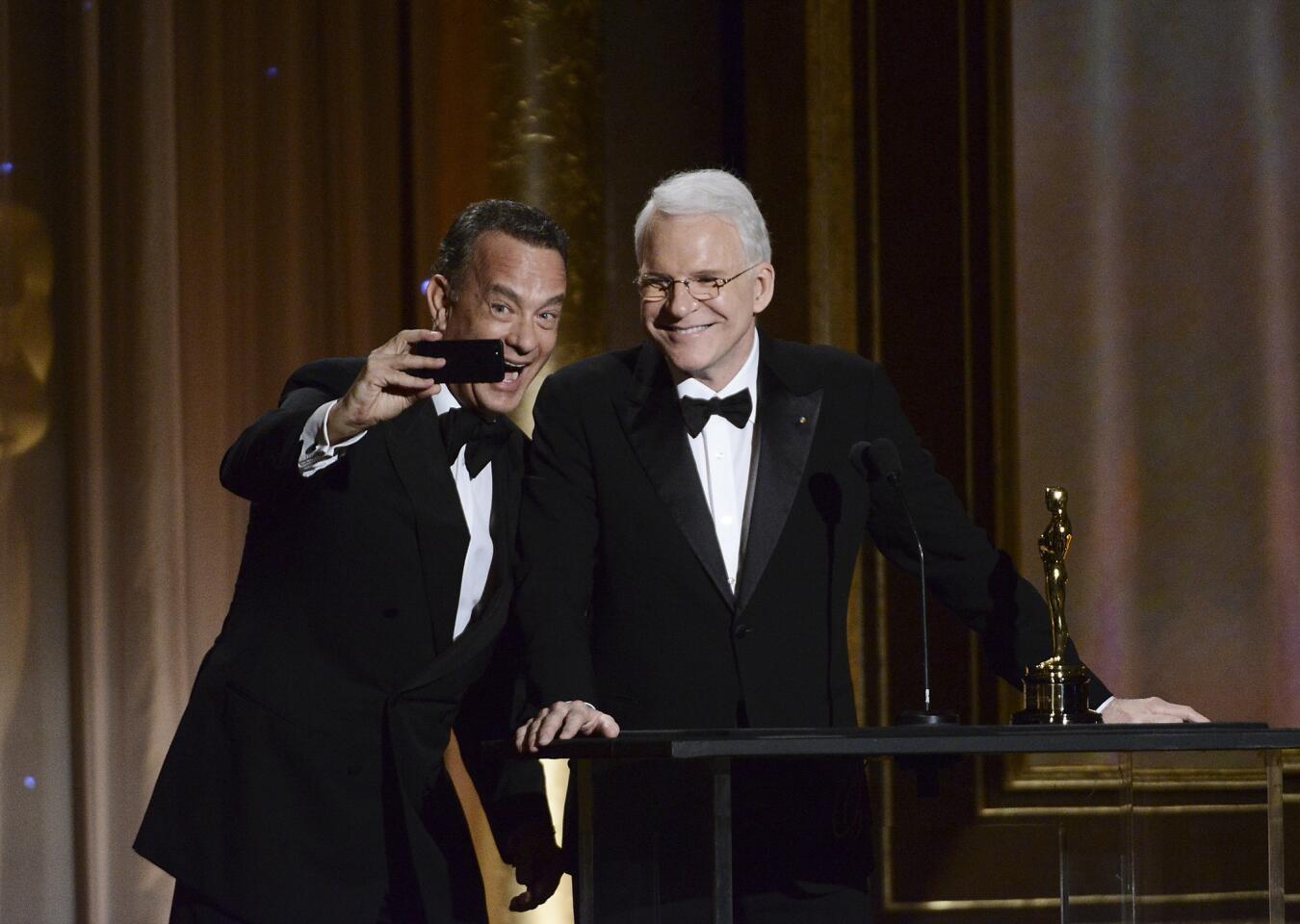 Actor Tom Hanks, left, takes a photo with actor and honoree Steve Martin at the 2013 Governors Awards in Los Angeles.