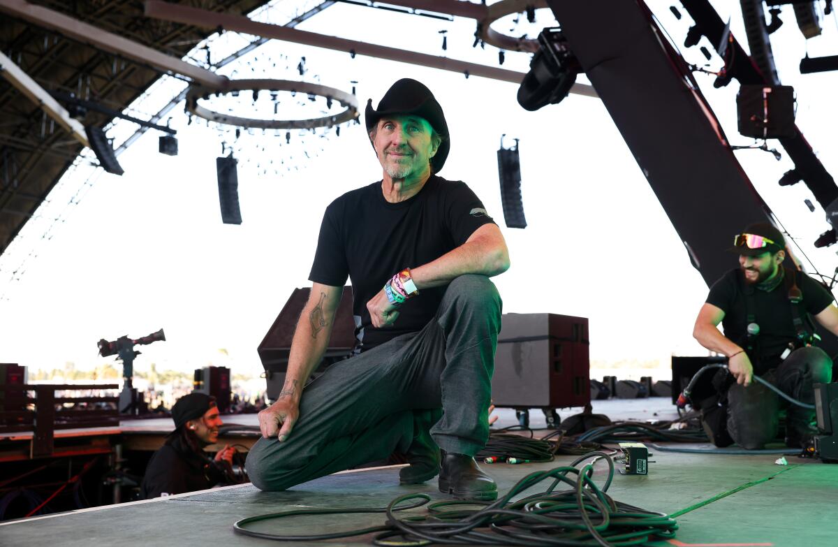 Man in a black cowboy hat on stage next to sound gear at Coachella
