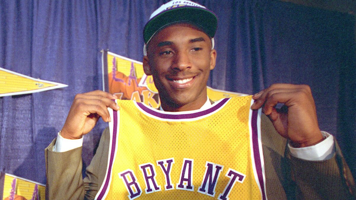 Lakers guard Kobe Bryant holds up his jersey during his introductory news conference on July 12, 1996.
