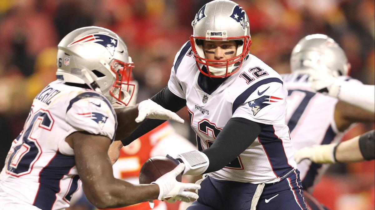 Patriots quarterback Tom Brady hands off the ball to running back Sony Michel during the second half of Sunday's win over the Kansas City Chiefs.