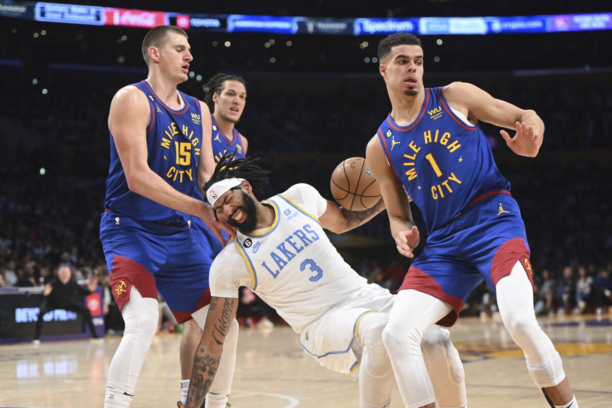 Lakers forward Anthony Davis falls in court after being fouled by Nuggets forward Michael Porter Jr.