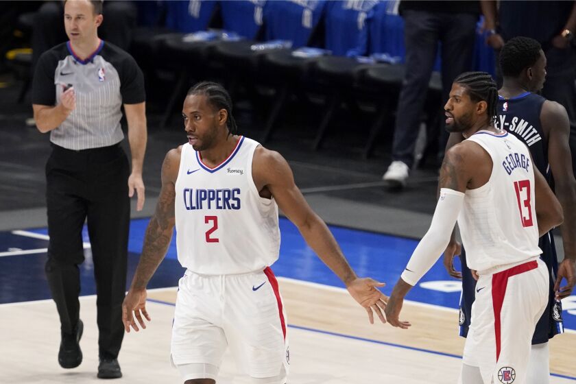Los Angeles Clippers' Kawhi Leonard (2) and Paul George (13) celebrate a basket in the closing seconds of Game 3 of an NBA basketball first-round playoff series against the Dallas Mavericks in Dallas, Friday, May 28, 2021. (AP Photo/Tony Gutierrez)