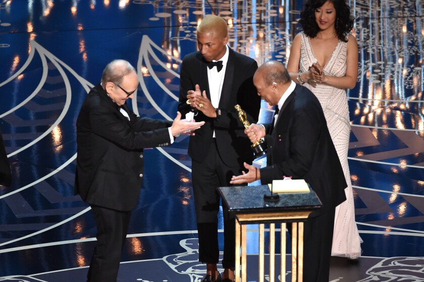 ''The Hateful Eight" composer Ennio Morricone accepts the Oscar for original score Sunday from Pharrell Williams, center, and Quincy Jones at the 88th Academy Awards.