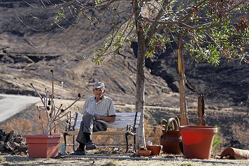 Jerome "Joe" Wier, 88, smokes his briar pipe and looks out at what used to be his 5,500-square-foot ranch-style home in Poway in San Diego County. The house, which he built himself, was lost in the October wildfires.