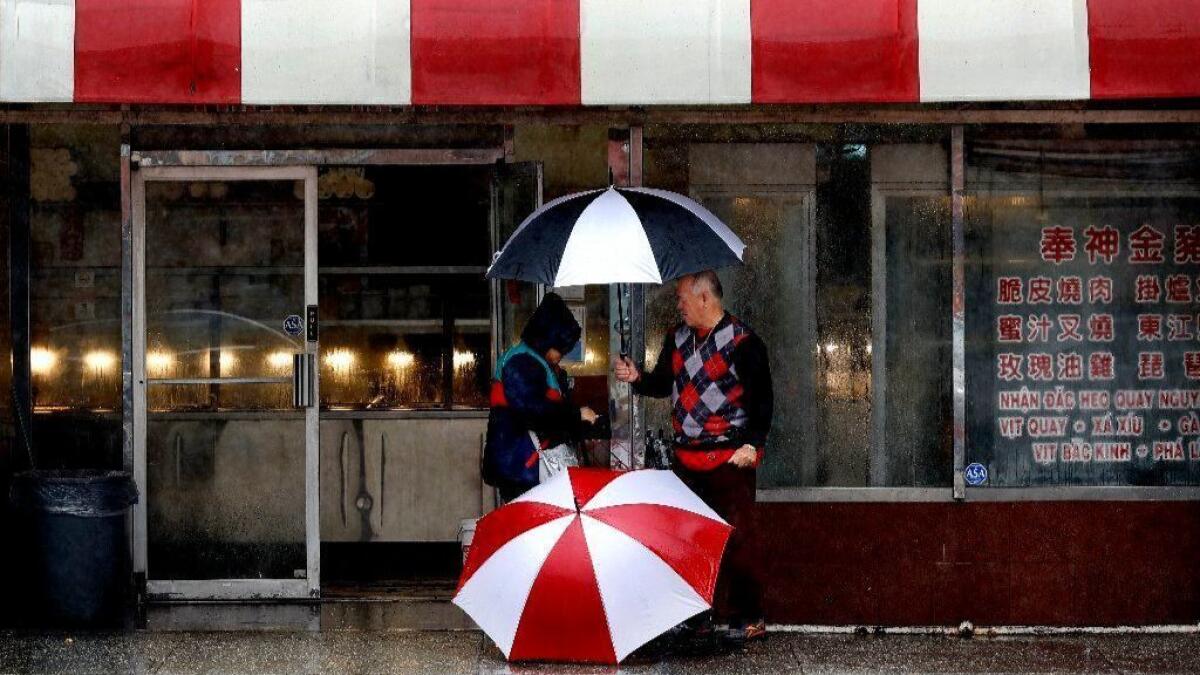 A vendor sells umbrellas on Broadway in Chinatown as a storm passed through the area last week.