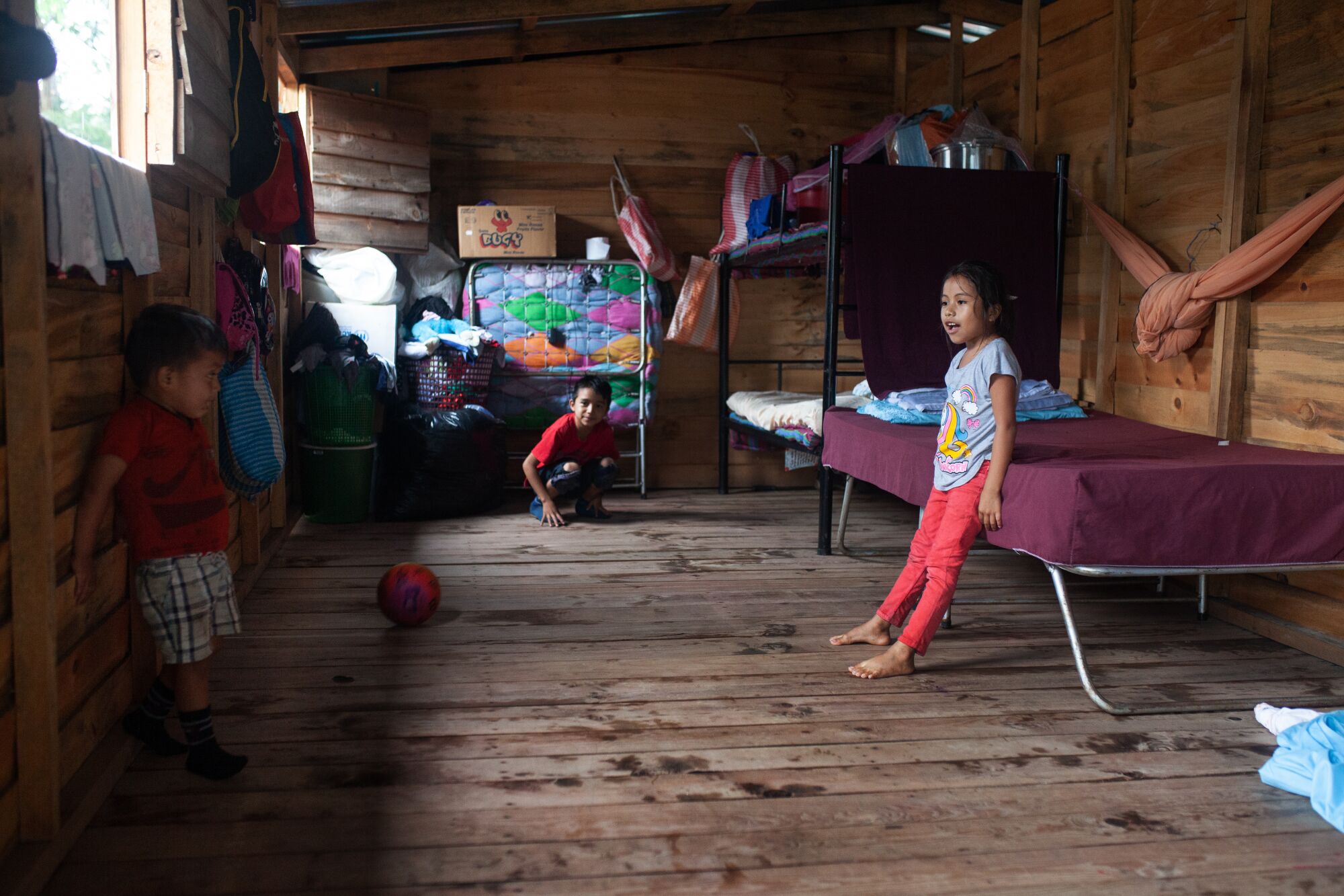 Children play inside a transitional shelter.
