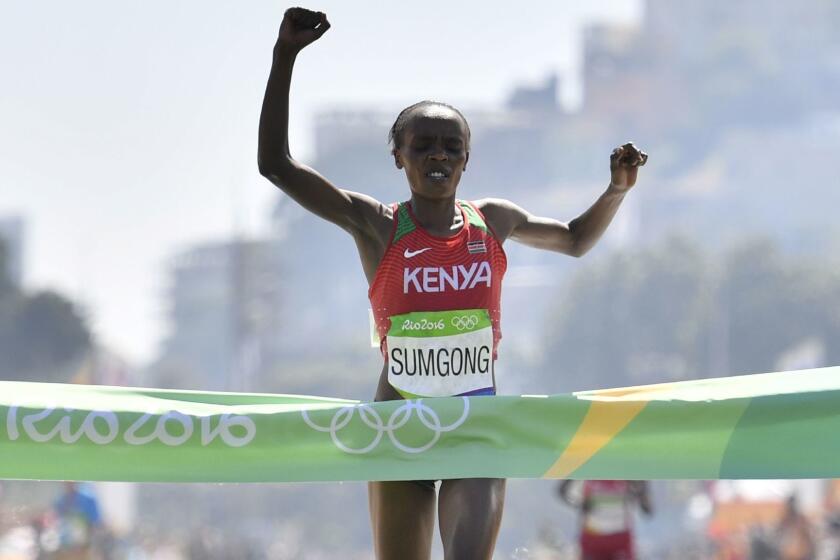 (FILES) This file photo taken on August 14, 2016 shows Kenya's Jemima Jelagat Sumgong raising her arms in victory as she crosses the finish line of the Women's Marathon during the athletics event at the Rio 2016 Olympic Games at Sambodromo in Rio de Janeiro. Kenya's Olympic marathon champion Jemima Sumgong has been suspended for four years for doping, Athletics Kenya said on November 7, 2017. / AFP PHOTO / Fabrice COFFRINIFABRICE COFFRINI/AFP/Getty Images ** OUTS - ELSENT, FPG, CM - OUTS * NM, PH, VA if sourced by CT, LA or MoD **