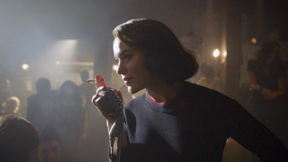 A woman leans toward a microphone in a smoky nightclub in 1960