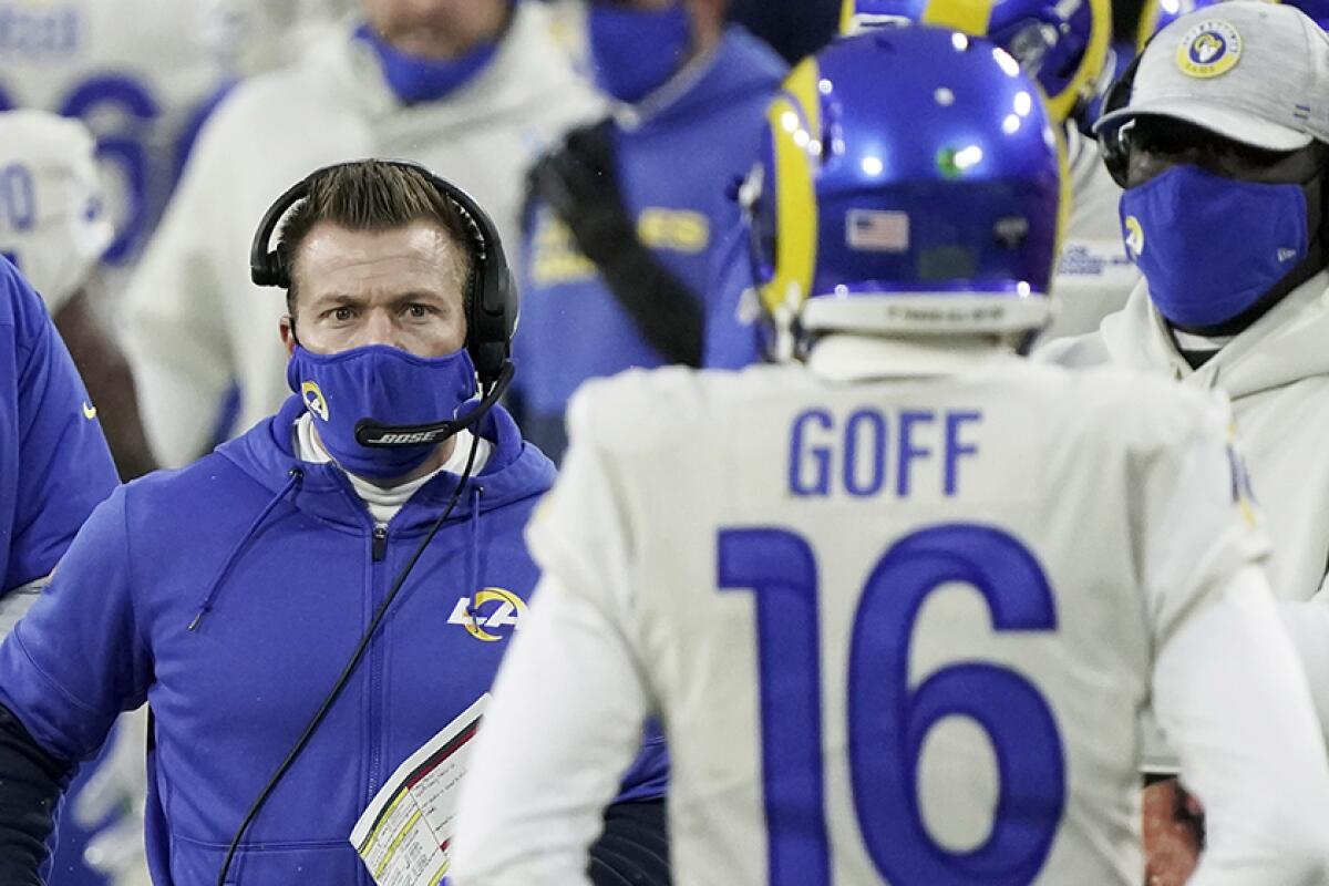 Rams coach Sean McVay and Jared Goff with staff members behind them.