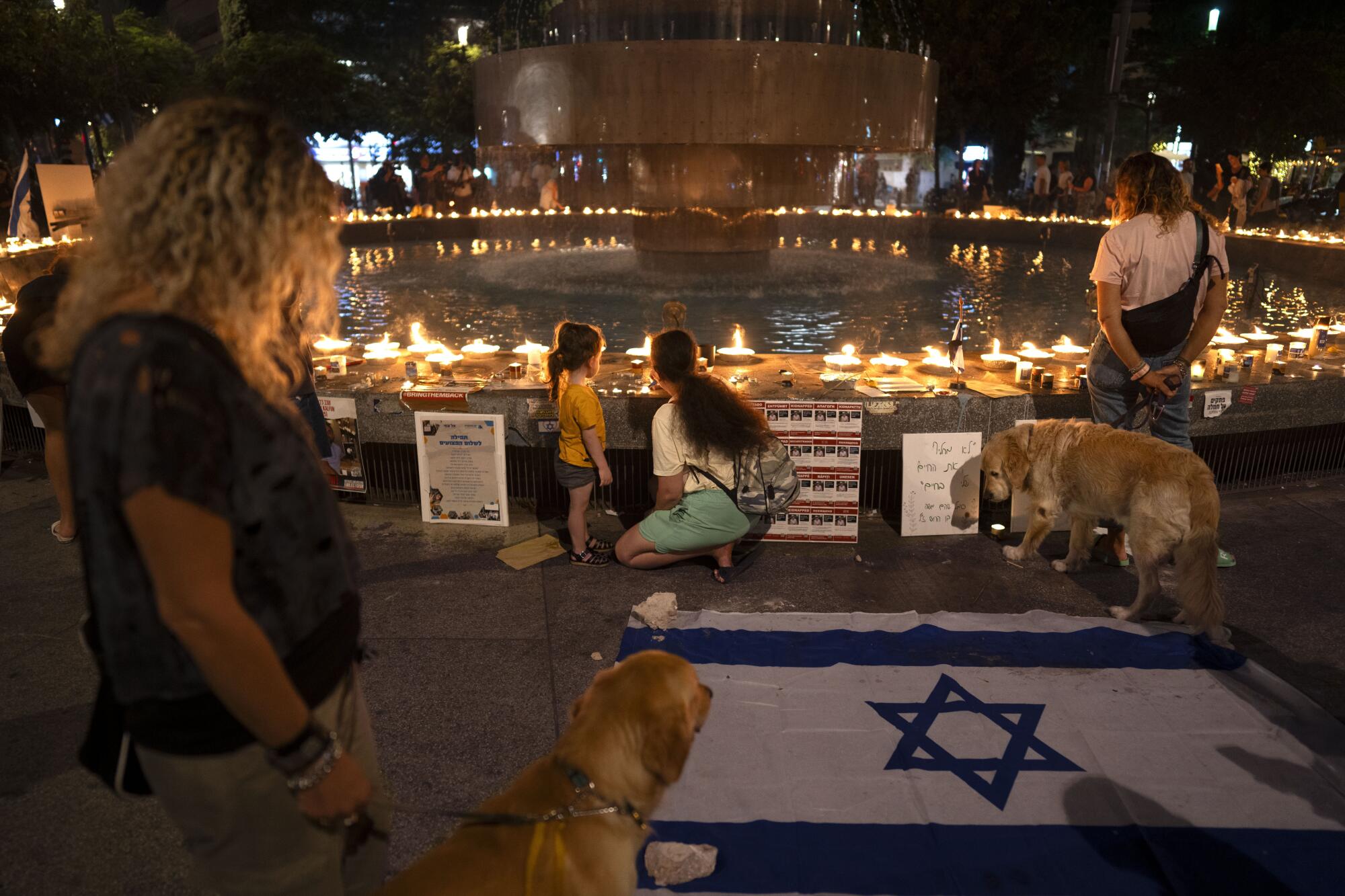 People lighting candles at a vigil marking a month since Hamas' attack on Israel