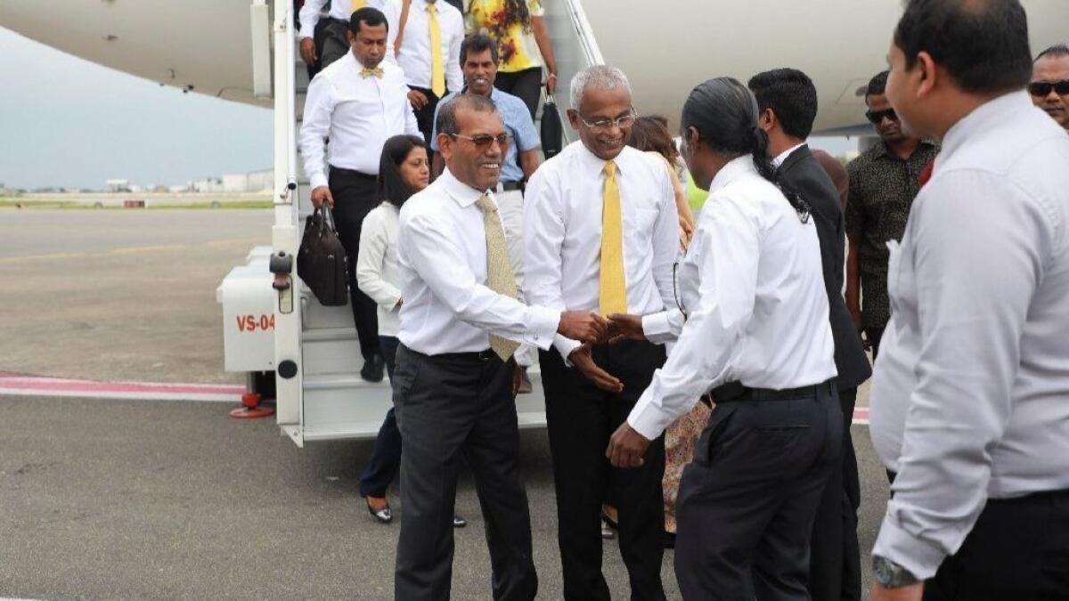 Former President Mohamed Nasheed, center left, is greeted by supporters upon returning to the Maldives, Nov. 1, 2018. To his left is President-elect Ibrahim Mohamed Solih.