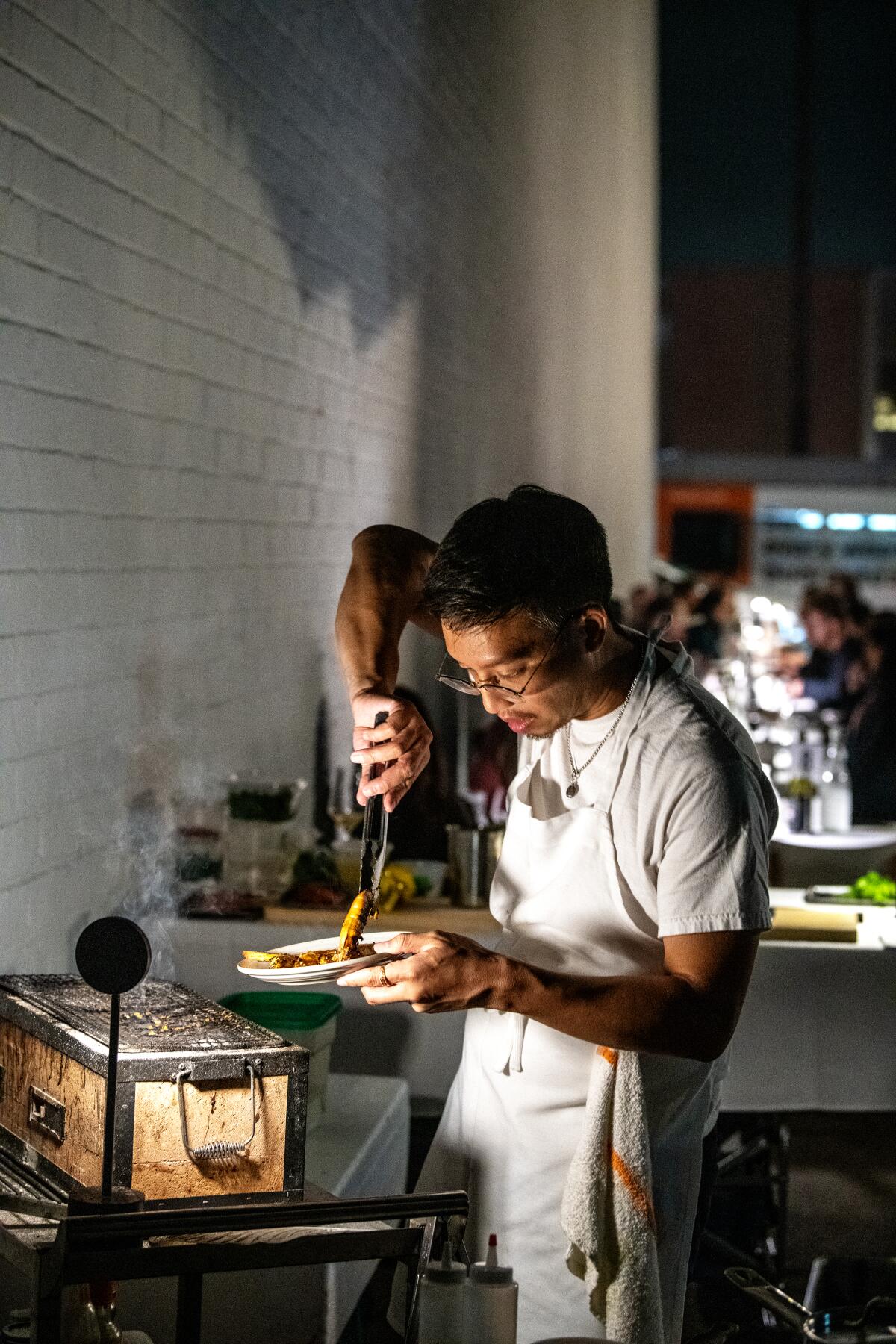 A chef cooks outside in an alley at night 