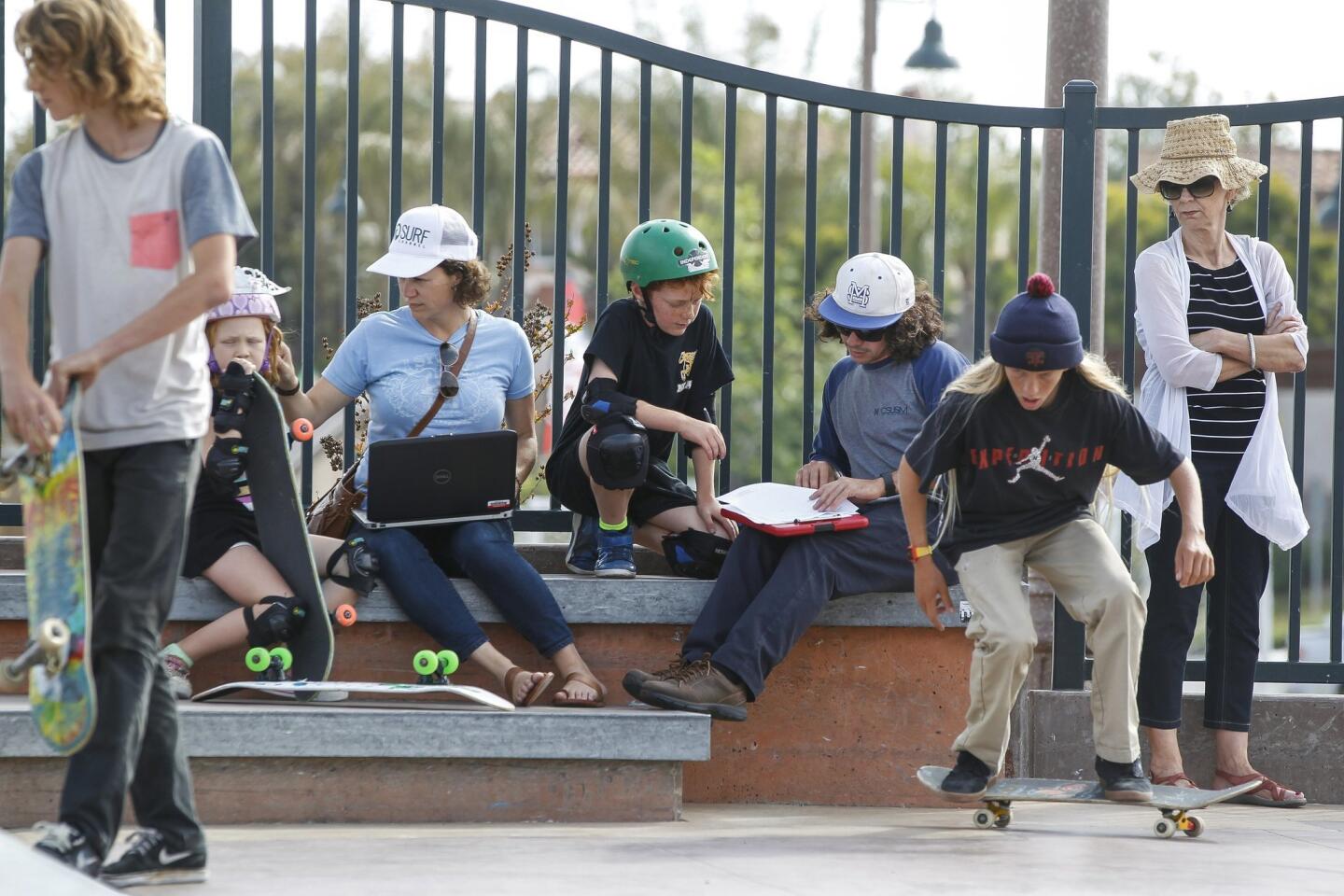 Cal State University San Marcos kinesiology intern Moses Wosk, 24, third from right, helps Jasper Bier, 10, with filling out the paperwork so that he can participate in the skateboarder study.