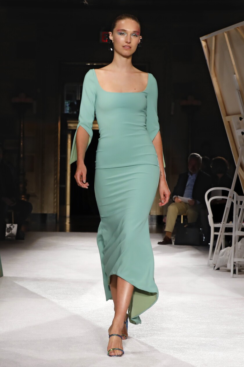 A model wears a sage green dress from Christian Siriano’s 2020 runway collection