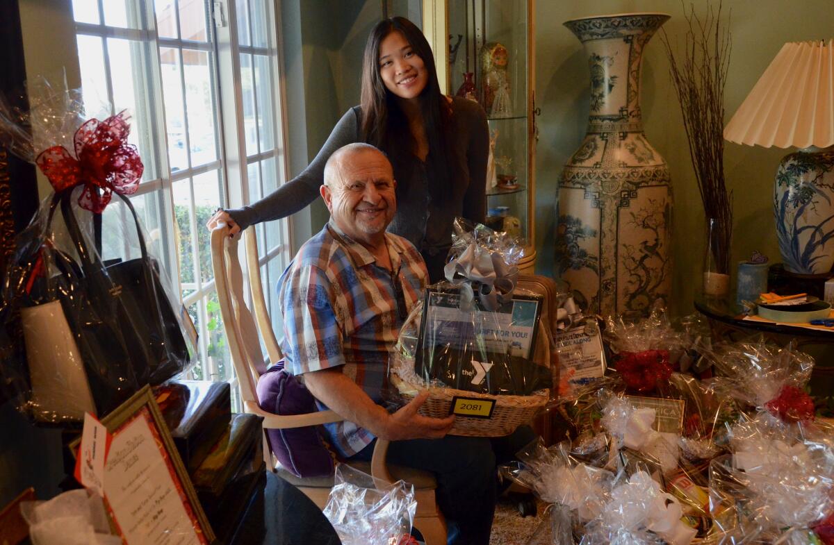 Giving It Back to Kids co-founder Robert Kalatschan of Huntington Beach and daughter Kristina, surrounded by gift baskets in their living room, prepare for the organization's Journey for Hope fundraiser, set for Saturday night in Newport Beach.