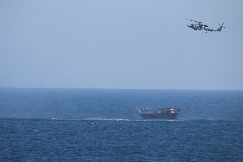 FILE - A U.S. Navy Seahawk helicopter flies over a stateless dhow later found to be carrying a hidden arms shipment in the Arabian Sea, May 6, 2021. The U.S. Navy's Mideast-based 5th Fleet will begin Tuesday, July 5, 2022, to offer rewards for information that could help sailors intercept weapons, drugs and other illicit shipments across the region. The program launches against the backdrop of tensions over Iran’s nuclear program and Tehran’s arming of Yemen’s Houthi rebels. (U.S. Navy via AP, File)