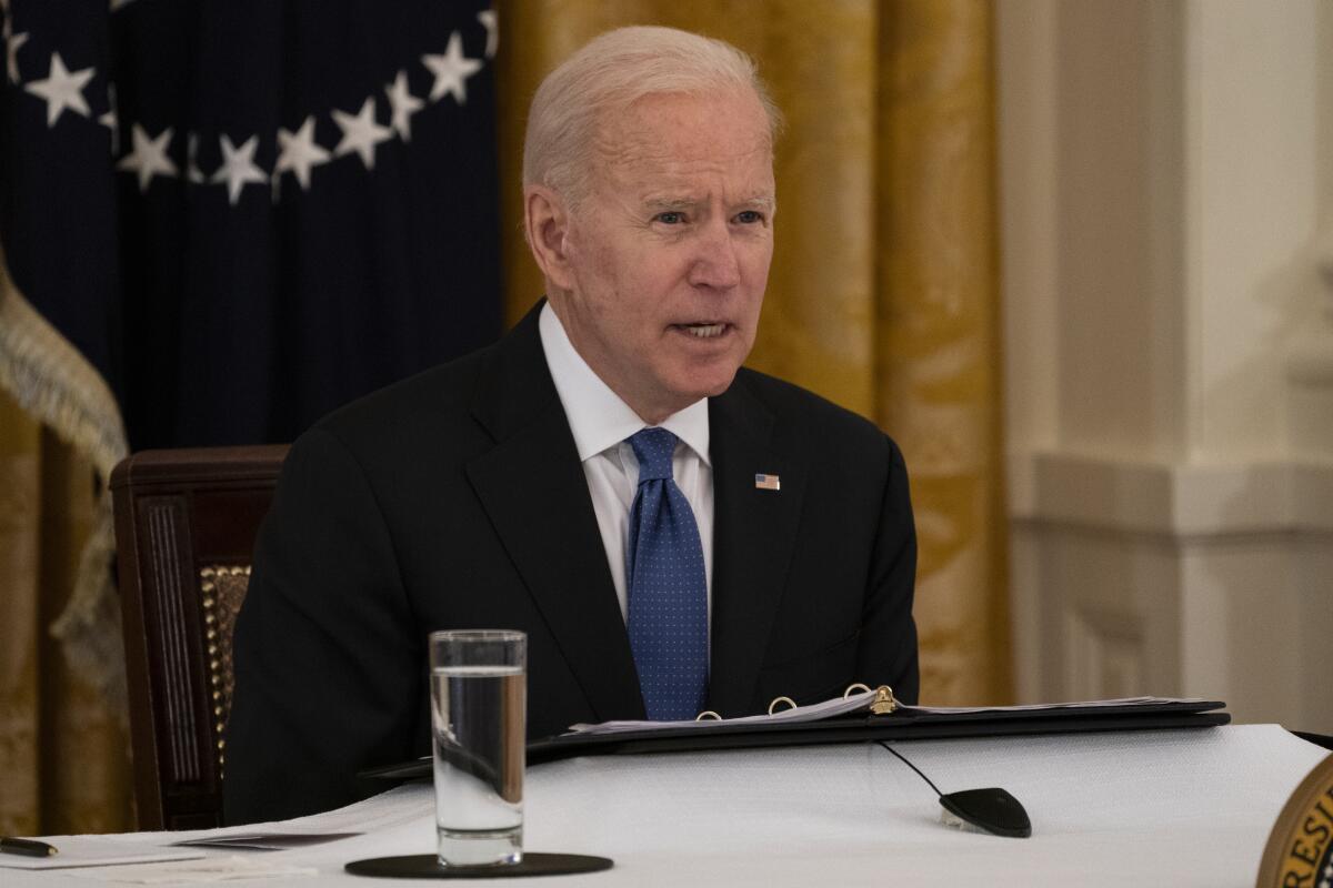 President Biden speaks seated at a table