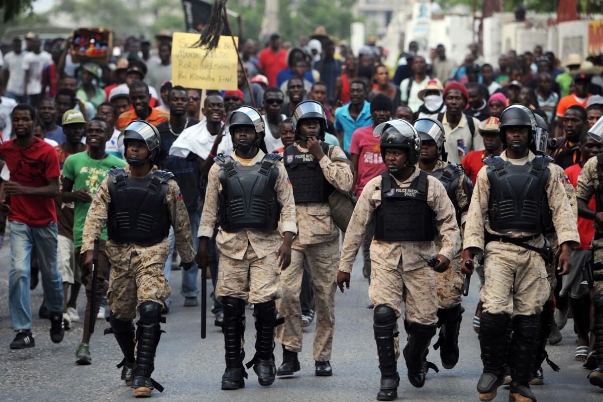 Haitian police patrol the street during a protest in Port-au-Prince on Monday.