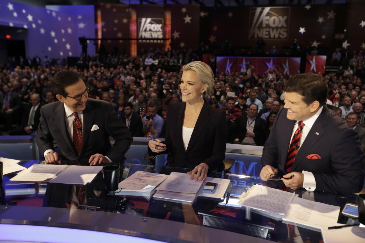 Moderators Chris Wallace, from left, Megyn Kelly and Bret Baier smile as they wait for the start of Thursday's Republican presidential debate in Des Moines, Iowa.