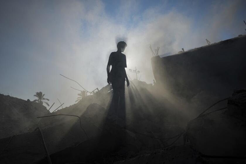 A Palestinian child inspects the rubble of a school destroyed in an Israeli airstrike on Deir al-Balah, central Gaza Strip, Saturday, July 27, 2024. (AP Photo/Abdel Kareem Hana)