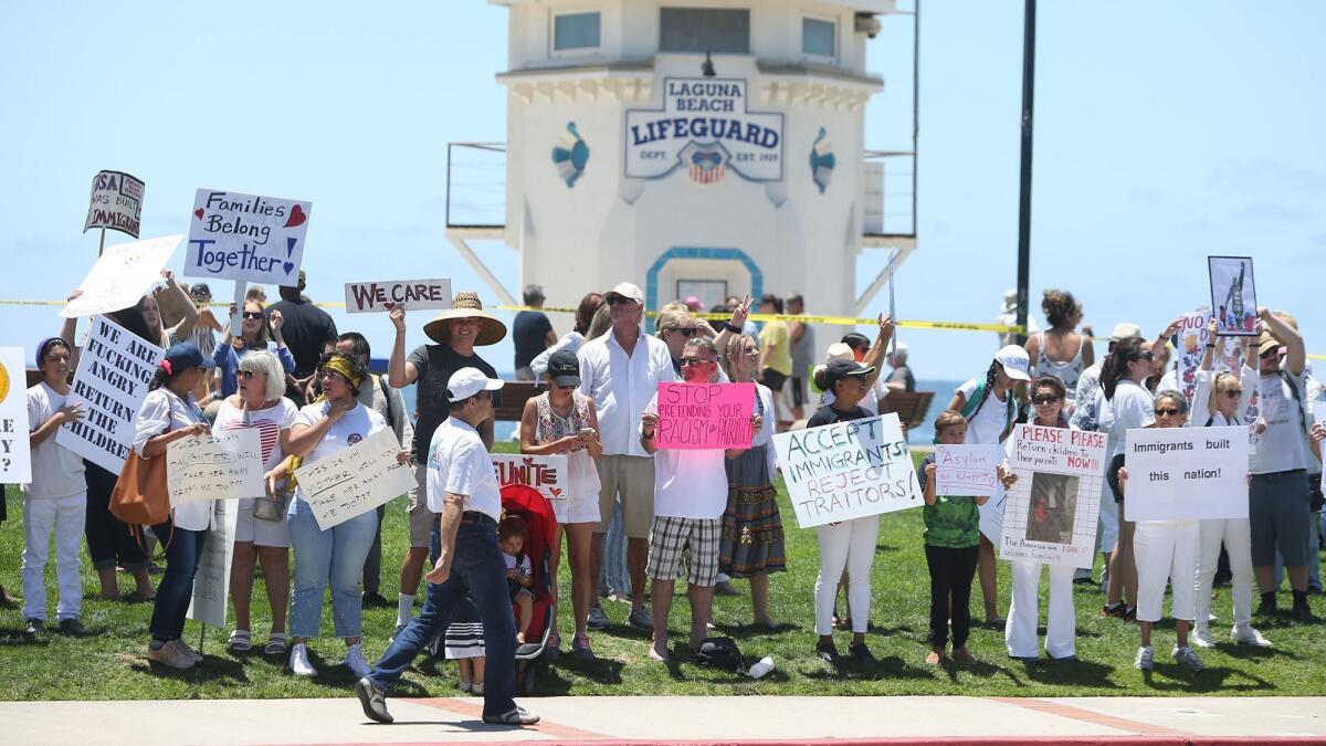 Demonstrators gather to protest the latest Trump administration immigration policies at Main Beach in Laguna Beach on Saturday.