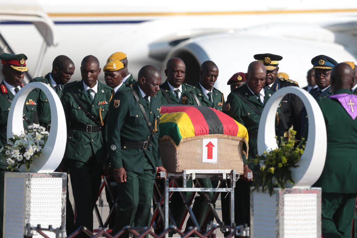 Members of the Presidential Guard stand beside the coffin of late former President Robert Mugabe upon its arrival in Harare, Zimbabwe, on Wednesday.