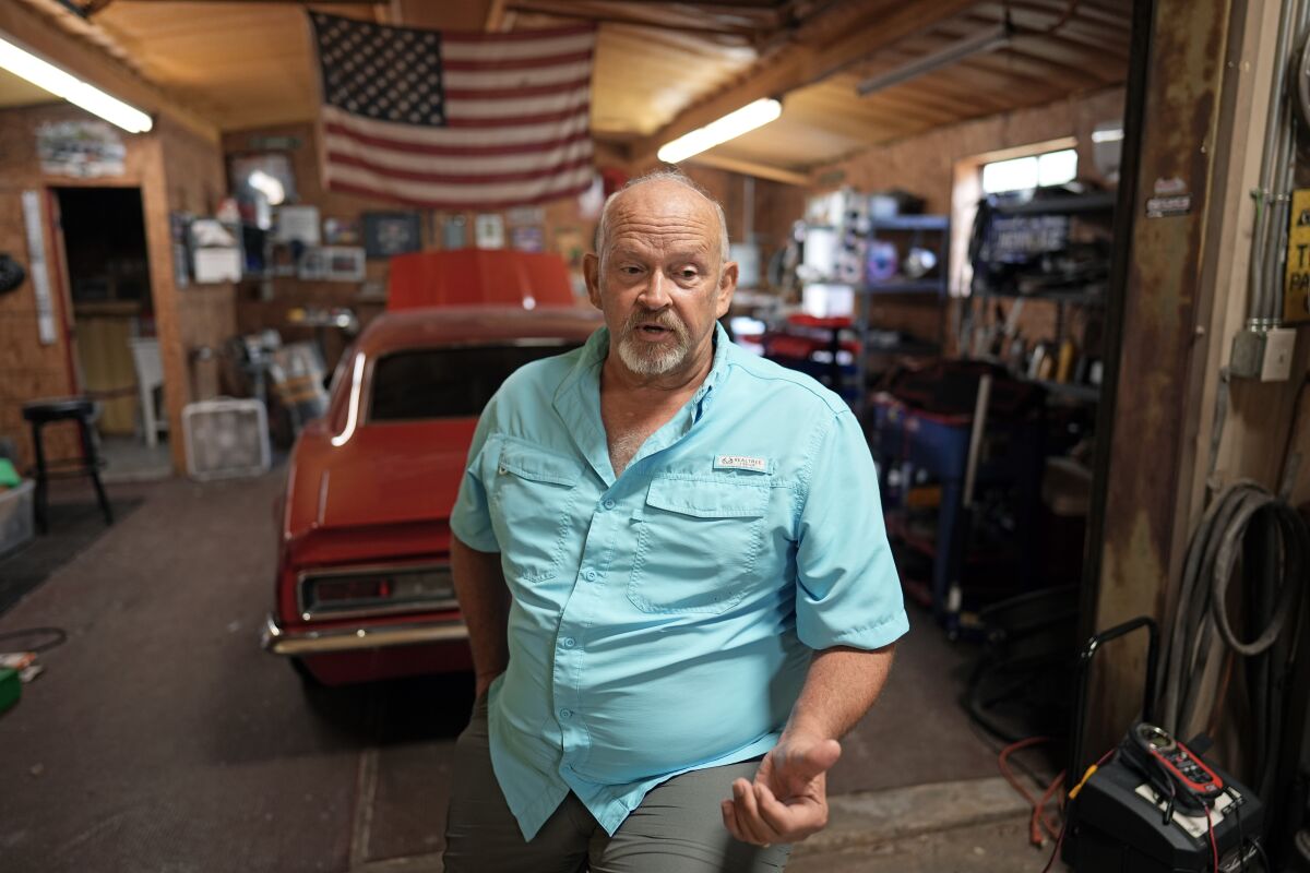 Retired Houston Fire Captain Russell Harris poses for a photograph inside his workshop at his home Wednesday, June 22, 2022, in East Bernard, Texas. (AP Photo/David J. Phillip)