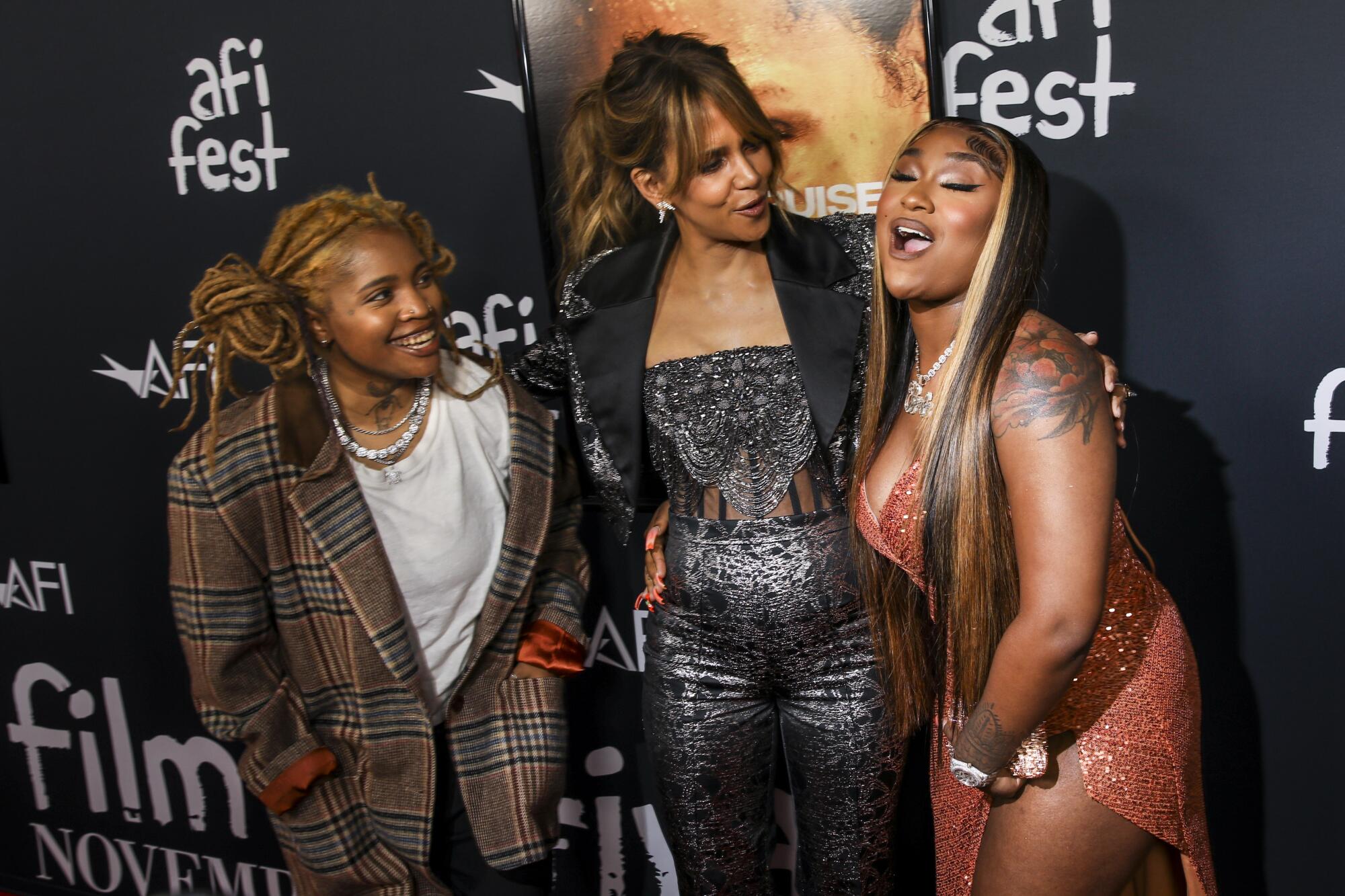 Halle Berry poses with Ambre and Erica Banks with a backdrop with AFI Fest logos.