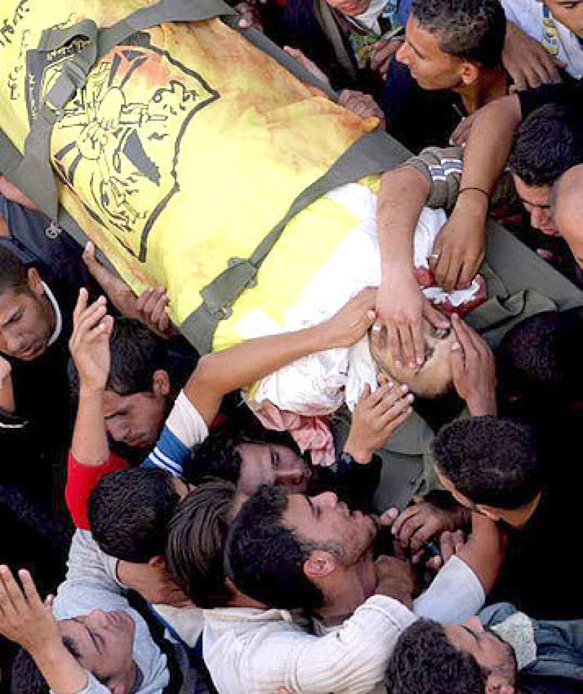 MOURNING: One of the Palestinian dead is carried through the streets of Beit Hanoun. We know the victims and we know the killer, a relative said.