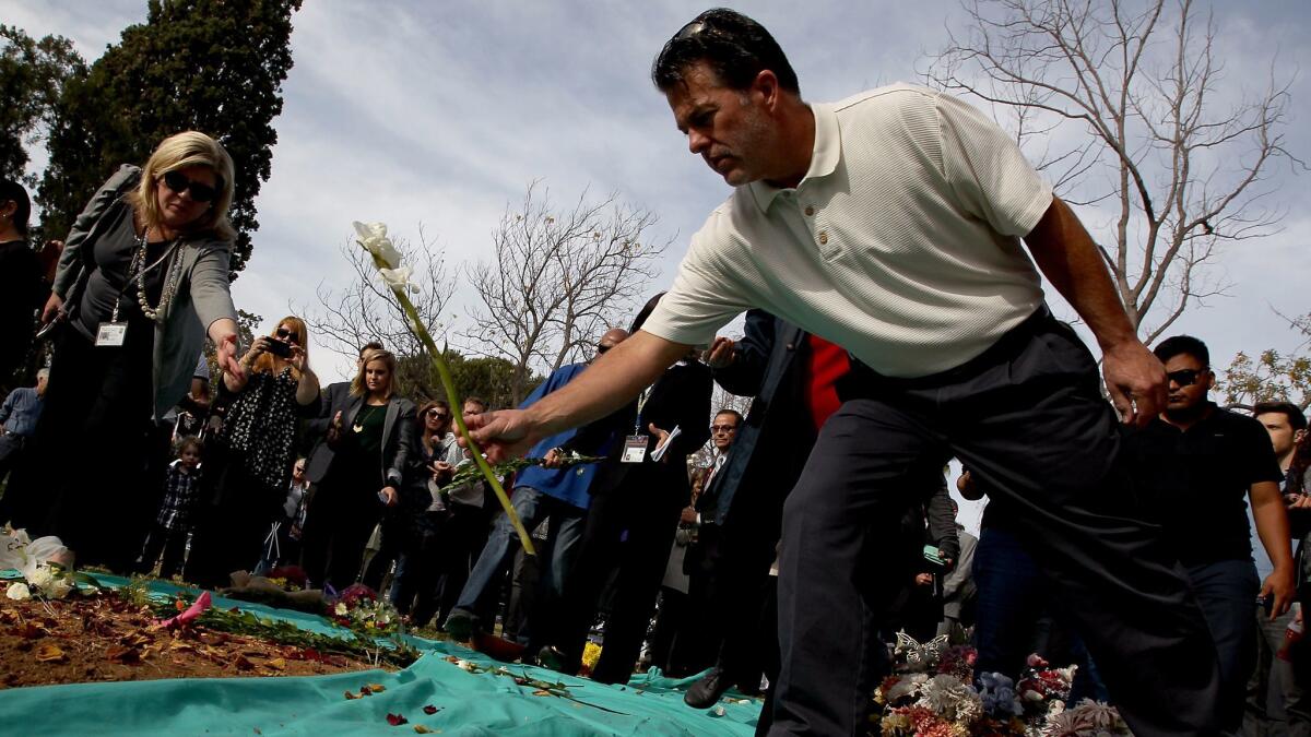 Dozens of mourners leave flowers following a mass burial of L.A. County's unclaimed dead at the county cemetery in Boyle Heights in December 2015.