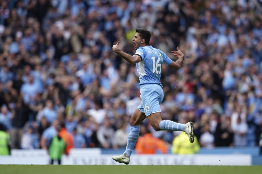Manchester City's Rodrigo runs to celebrate after scoring his sides second goal during the English Premier League soccer match between Manchester City and Aston Villa at the Etihad Stadium in Manchester, England, Sunday, May 22, 2022. (AP Photo/Dave Thompson)