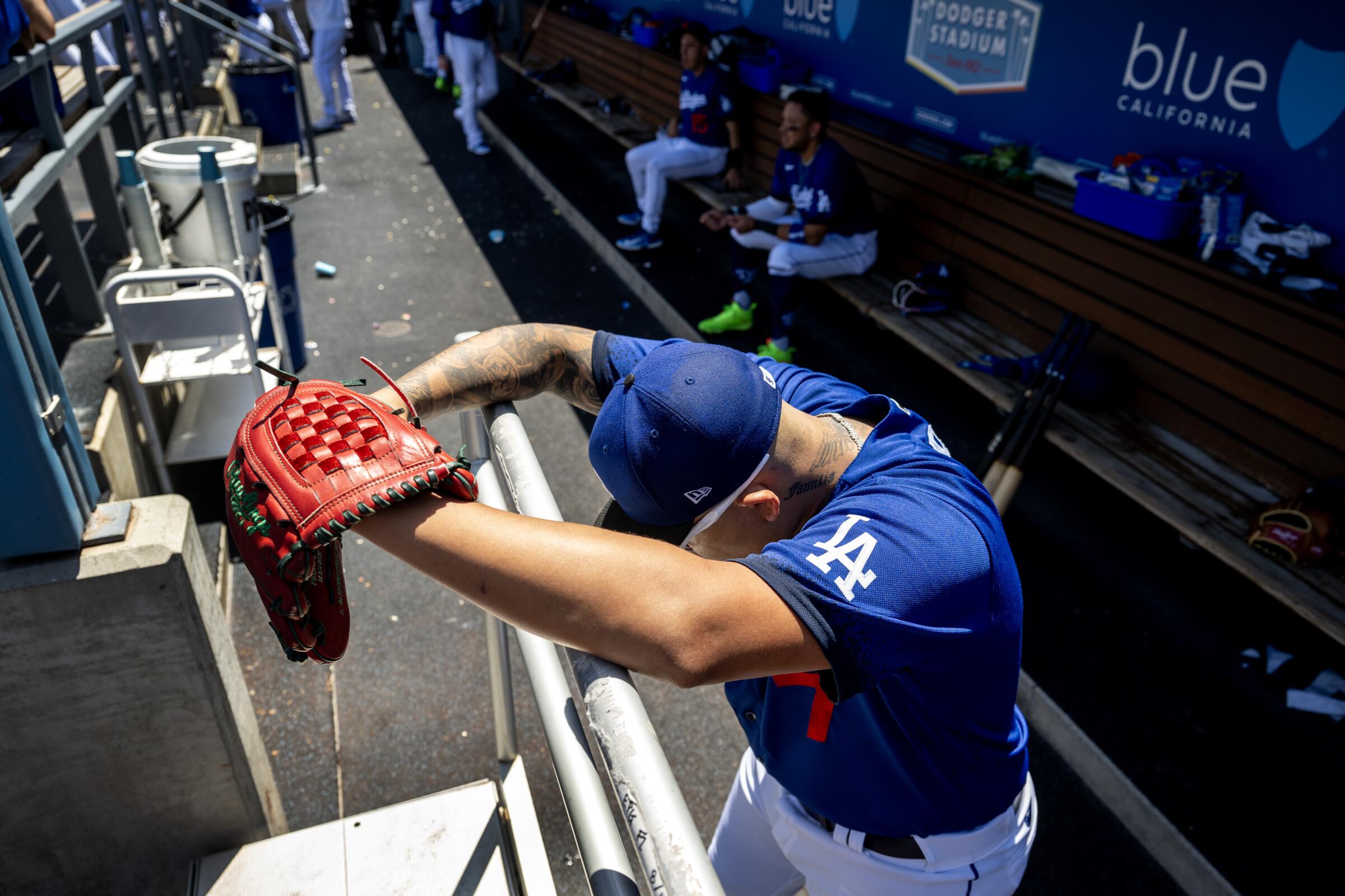 Dodgers starting pitcher Julio Urias stares down at the ground in the dugout during a game last month at Dodger Stadium.