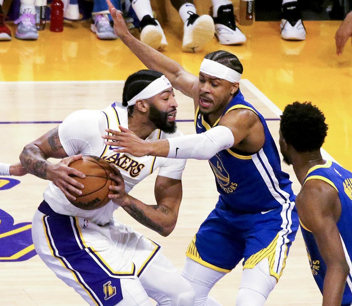 Lakers forward Anthony Davis, left, drives to the basket against Warriors guard Moses Moody.