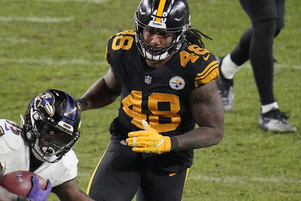 FILE - In this Dec. 2, 2020, file photo, Pittsburgh Steelers outside linebacker Bud Dupree (48) defends as Baltimore Ravens running back Gus Edwards (35) carries the ball during the second half of an NFL football game in Pittsburgh. Dupree, the Tennessee Titans’ prized free-agent offseason signing, made his practice debut on Friday, Aug. 6, 2021, after passing a physical and departing the team’s physically unable to perform (PUP) list. (AP Photo/Gene J. Puskar, File)