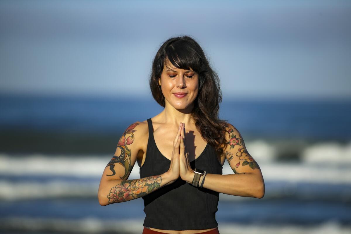 Instructor Laura Schwartz practices yoga on the beach in Carlsbad
