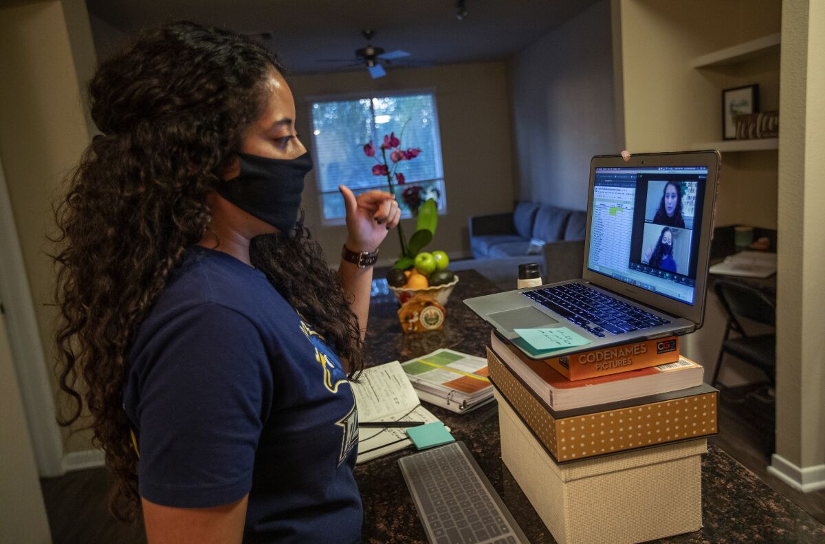 Cynthia Medrano, a college counselor at Alliance Marine Tech High School, works remotely at her home with students.