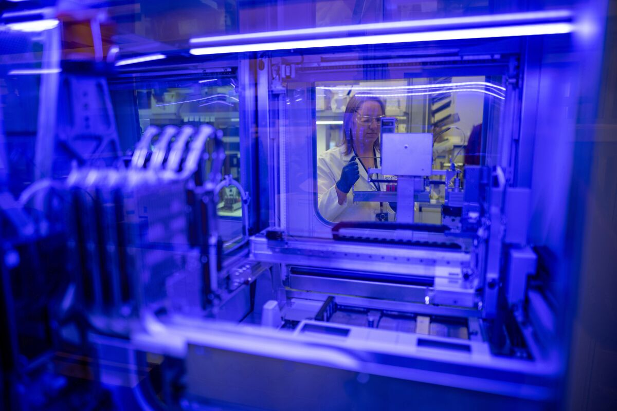 Katie Zegarski, supervising clinical lab scientist with the Department of Pathology and Laboratory Medicine at UC Davis Health, runs through the process of loading samples into a new testing instrument for the virus that causes COVID-19.